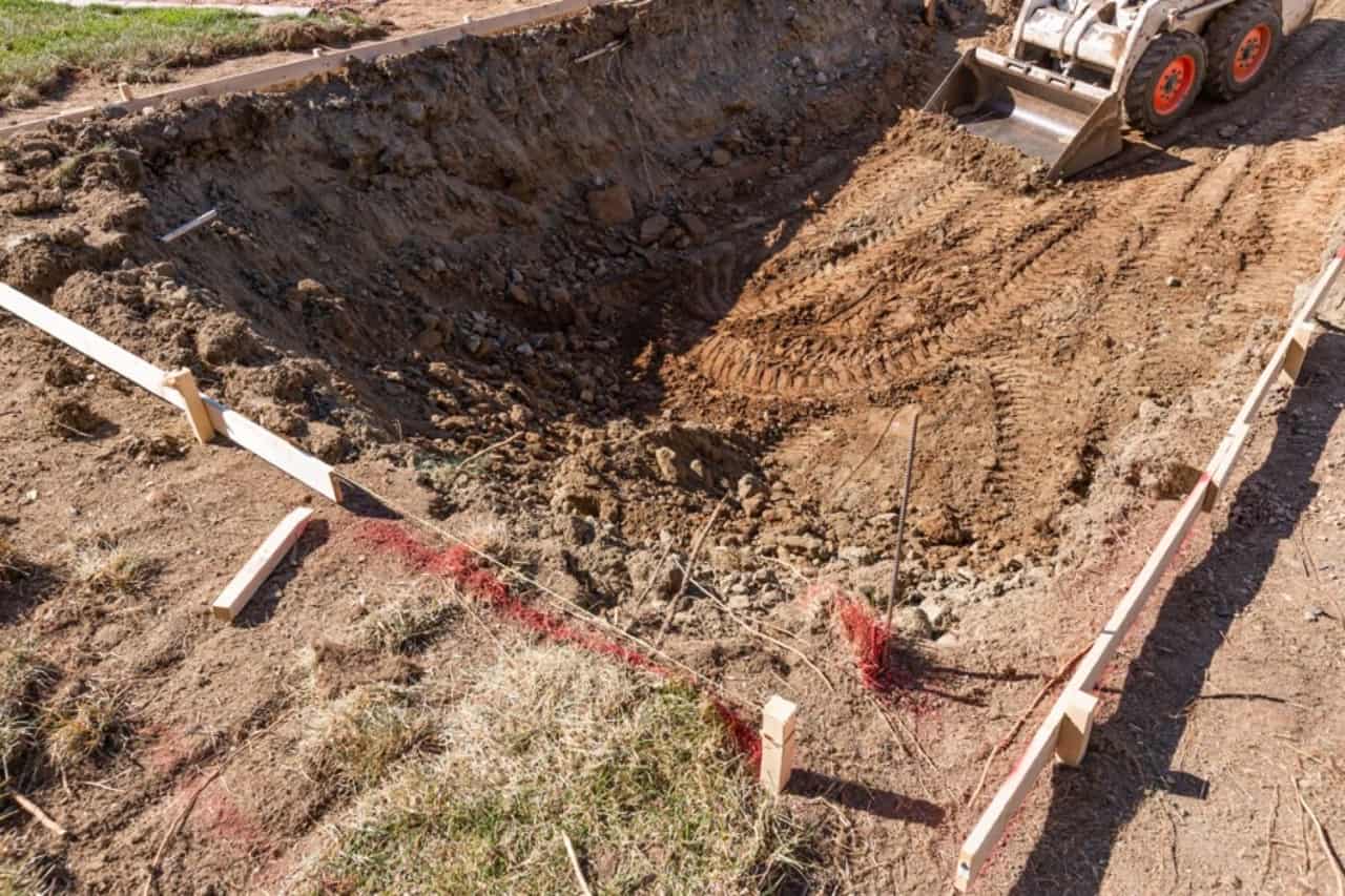 Excavator digging for a new custom pool installation
